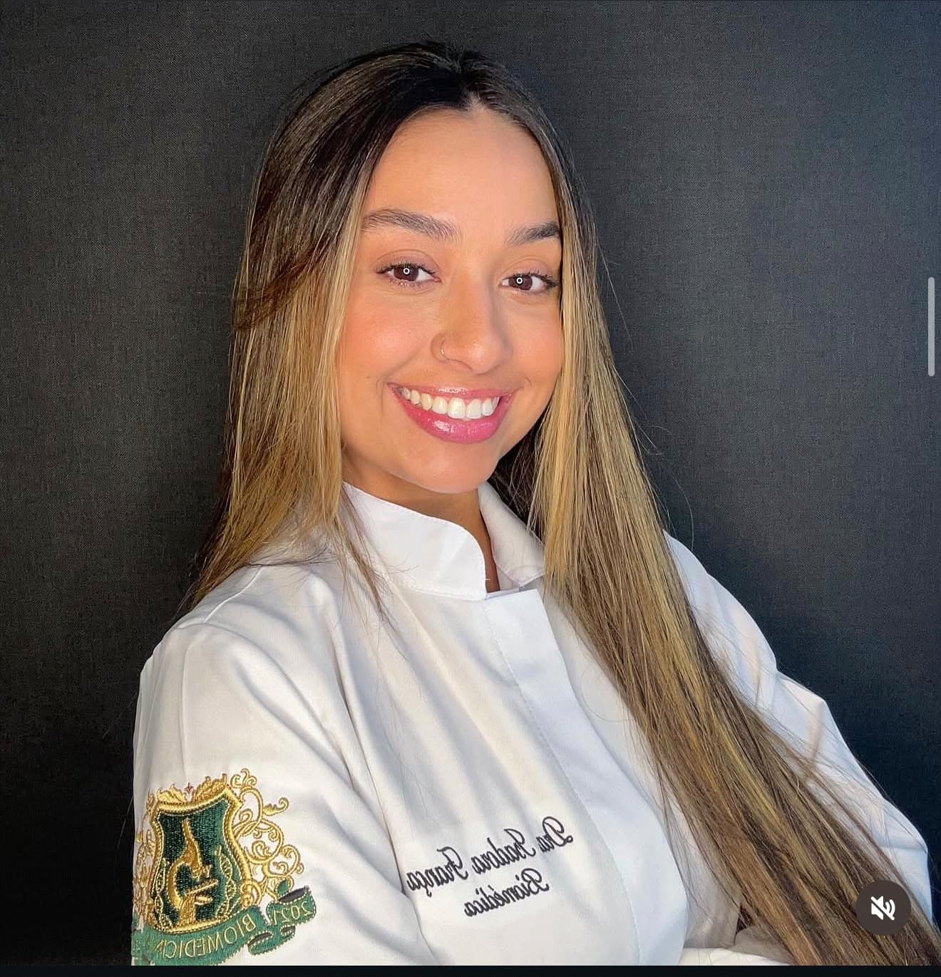 Isadora França Silva sorrindo, usando jaleco branco.